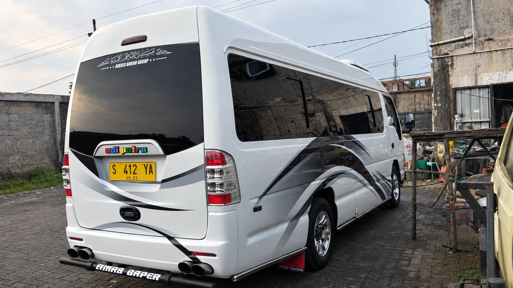 Tampak belakang Isuzu Elf Long putih armada Surya Abadi Transindo